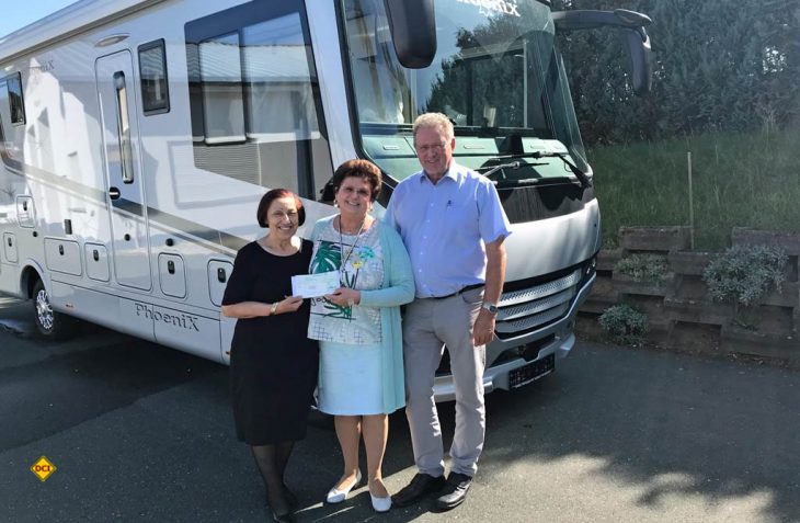 Maria Reisch (links) überreicht den Spenden-Scheck an die Ehepaar Schell von Phoenix Reisemobile. (Foto: Phoenix)